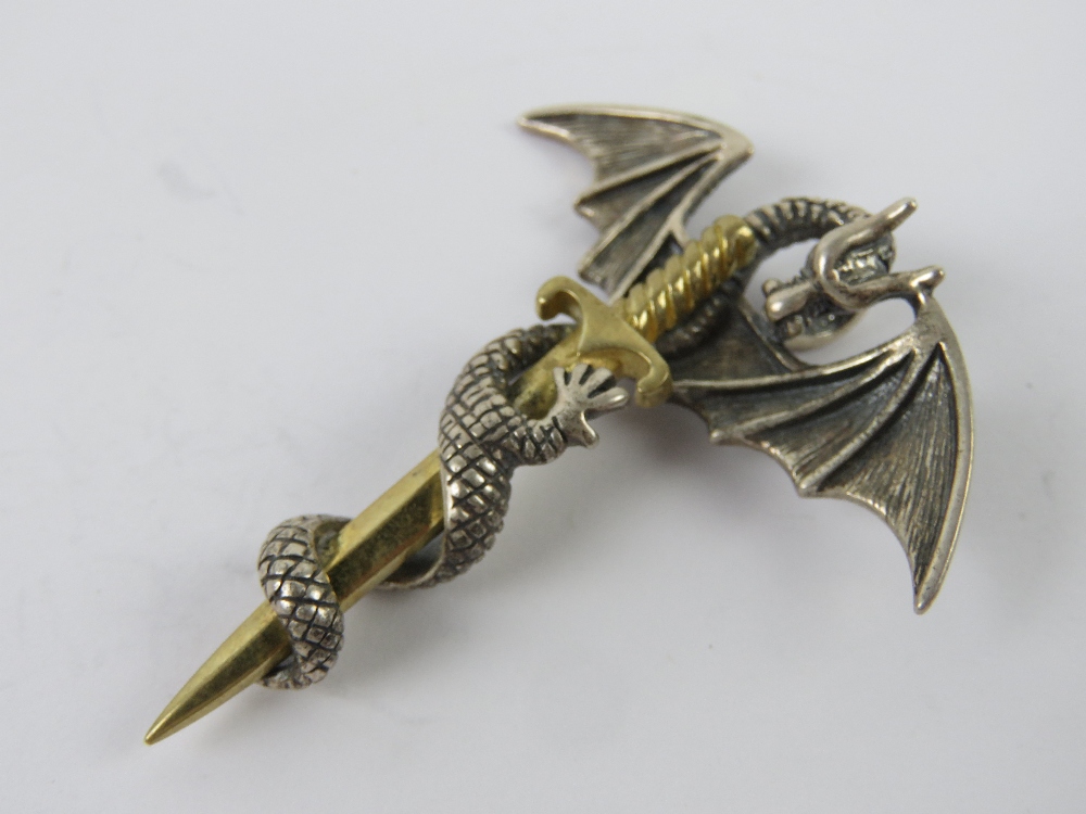 A silver dragon and sword pendant, stamp