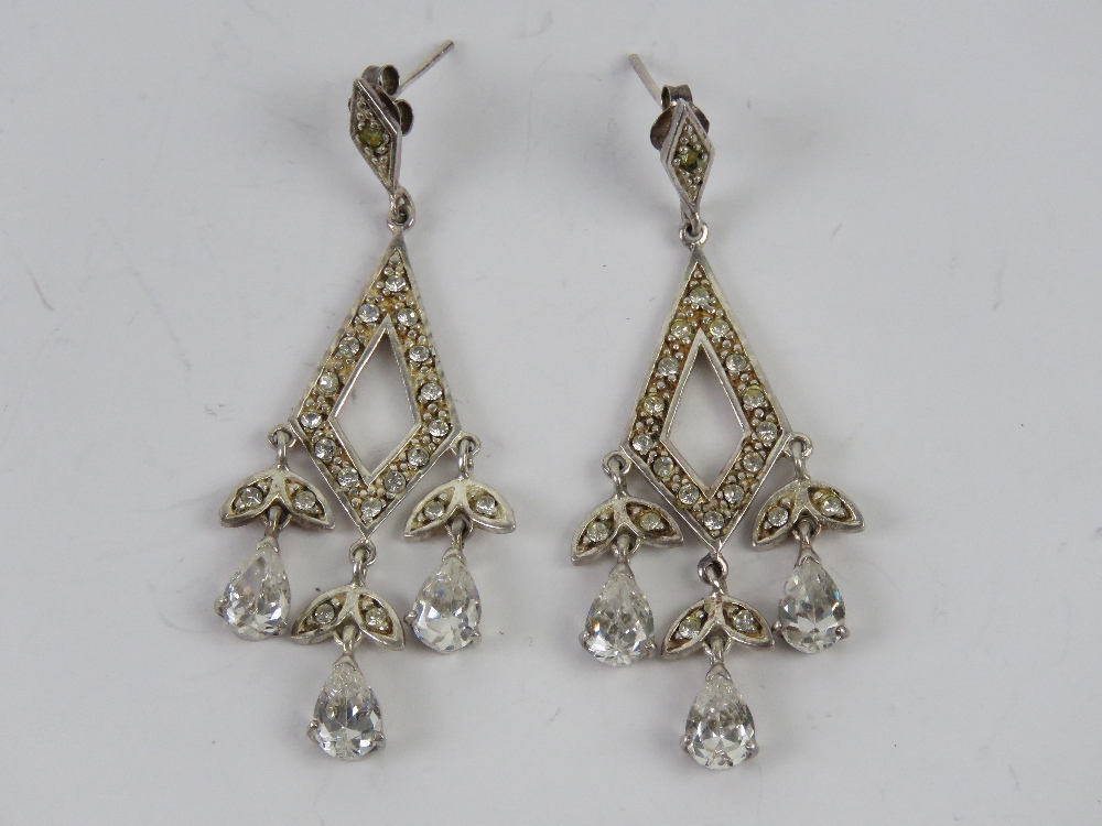 A pair of silver cocktail earrings havin