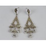 A pair of silver cocktail earrings havin