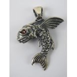 A flying fish pendant having red stone e