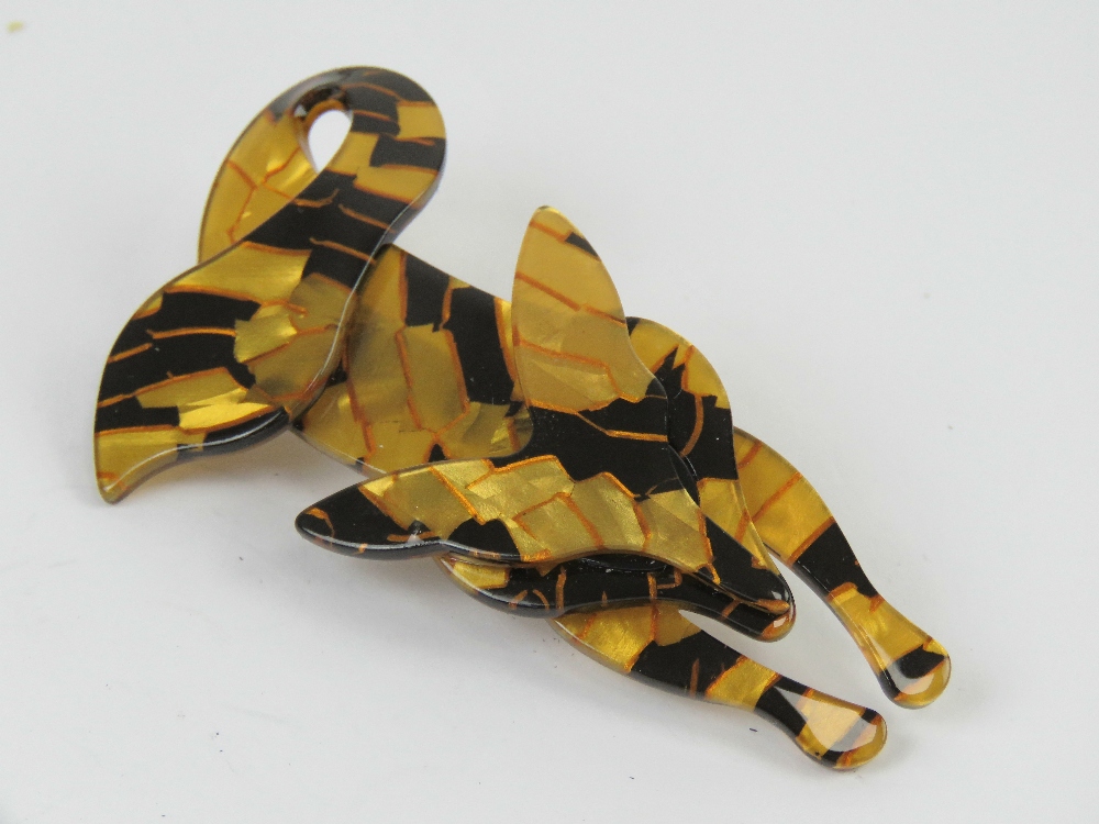 An overlaid plastic brooch in the style