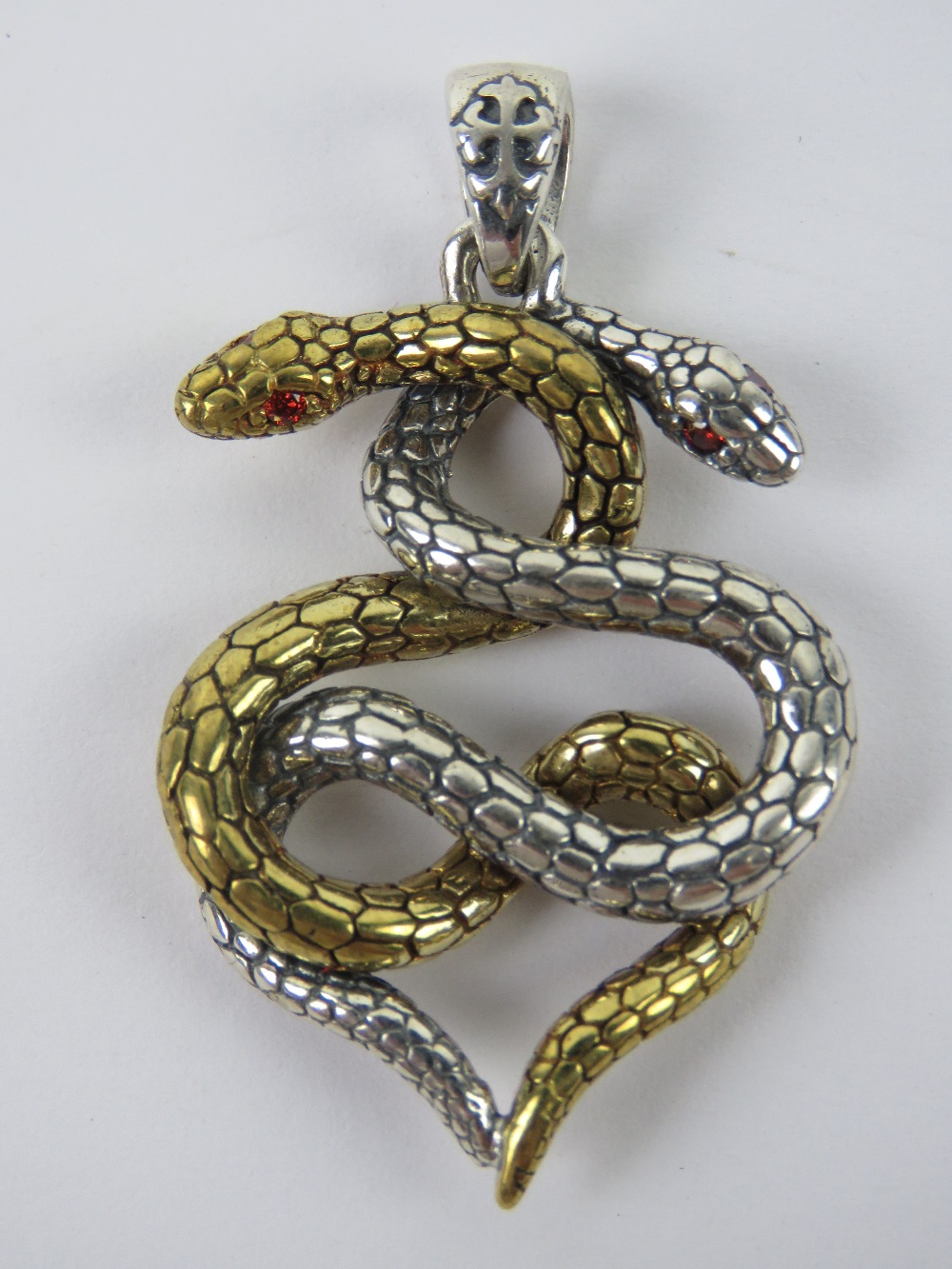 A silver pendant in the form of two entw