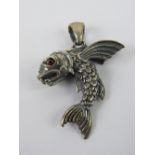 A flying fish pendant having red stone e