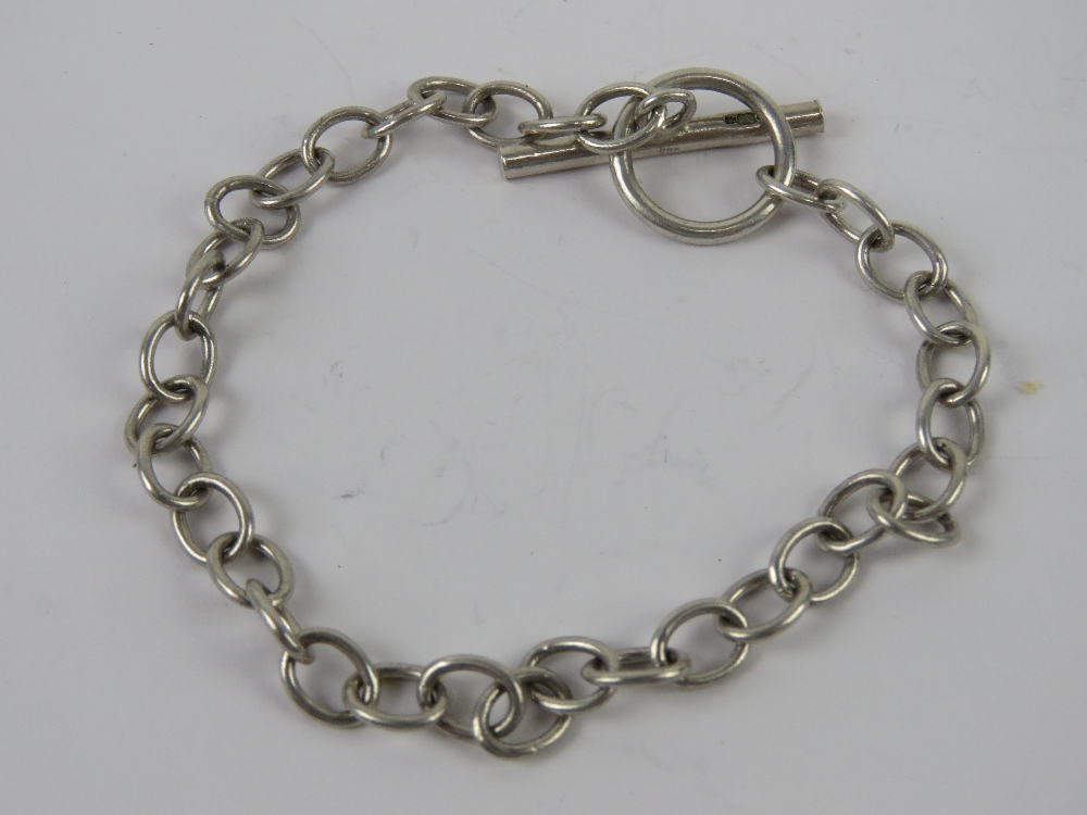 An HM silver charm bracelet having T-bar clasp, hallmarked 925 and measuring 18cm in length, 7.7g.