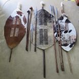 Four African spears together with two spear heads, three African animal hide shields etc.