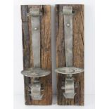 A pair of heavy blacksmith made oak and metal candle sconces, each 46cm in length.