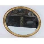 A contemporary oval bevel edged wall mirror, 55.5 x 45.5cm.