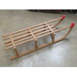 A wooden toboggan by Gloco West Germany measuring 109.5cm in length.