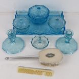 An early 20thC glass dressing table set comprising glass, candlesticks, lidded pots, ring holder,