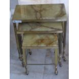 A nest of three onyx topped brass framed tables c1960s, each raise don wheels, 50,
