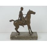 A cold cast bronze sculpture of jockey on horseback raised over marble base, 12cm wide,