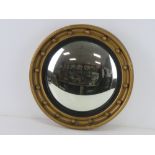 A convex circular wall mirror having black and gold painted frame, 41.5cm dia.
