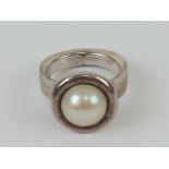 A silver and pearl ring, stamped 925 with makers mark GE, size N.