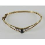 A vintage sapphire and white stone bangle, stamped very indistinctly (?)5 M(??) 9ct?,