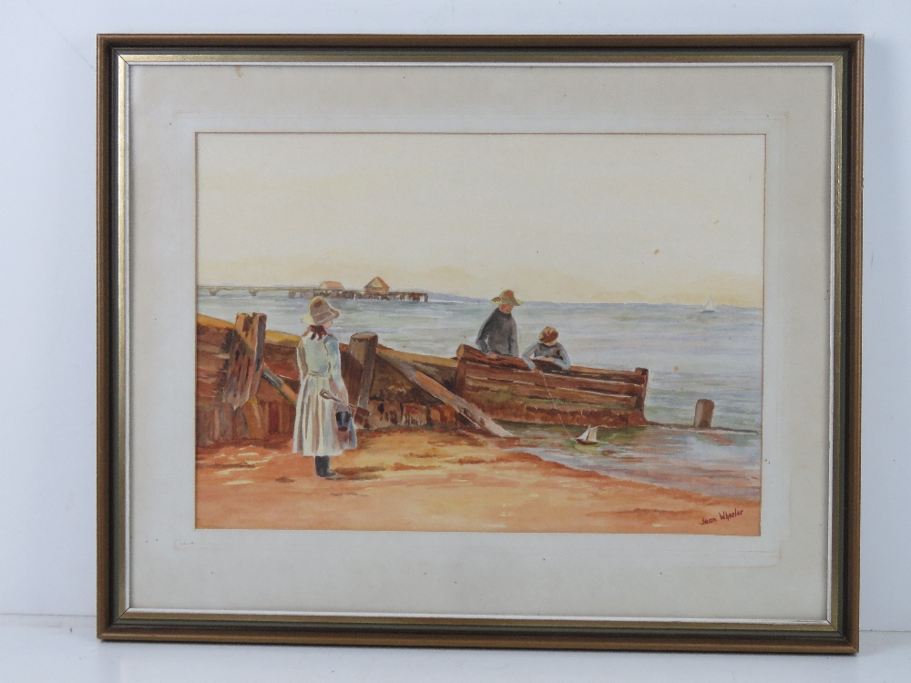 Watercolour by Jean Wheeler being a seaside scene of family with bucket and spade and model boat,