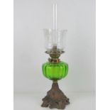 An oil lamp having green glass reservoir, etched glass shade, with chimney.