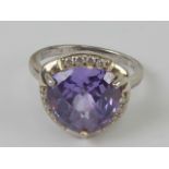 A silver cocktail ring having impressive central purple stone, stamped 925, size O-P.