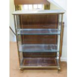 A qualitative brass framed open fronted three shelf cabinet raised over short cabriole legs,