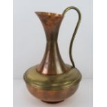 A large copper and brass jug standing 45