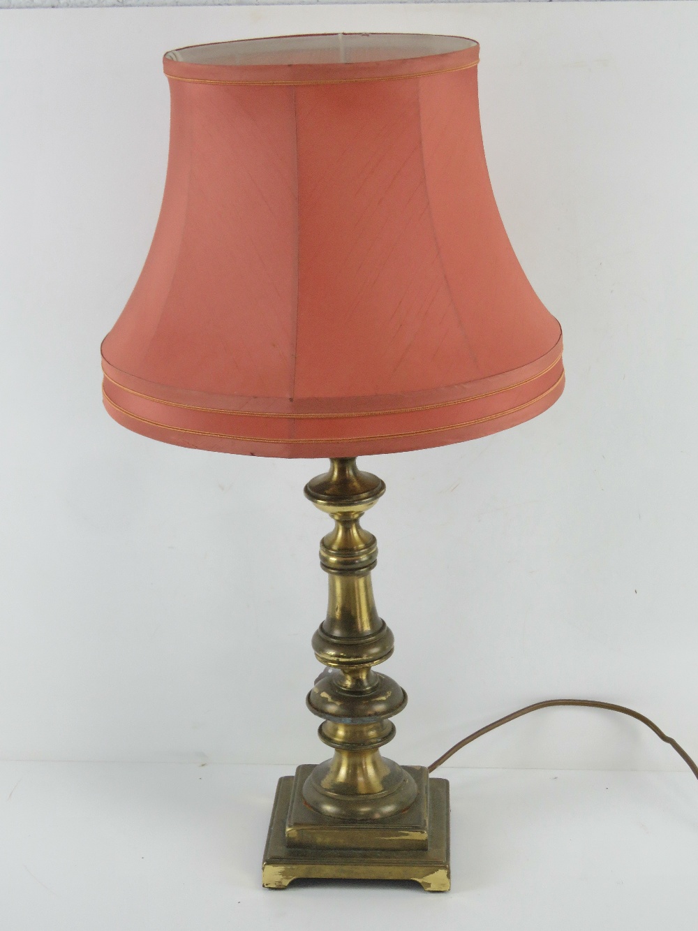 A brass table lamp having pink silk shad