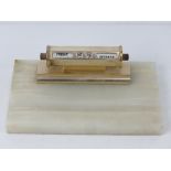 An alabaster desk tidy having calendar o