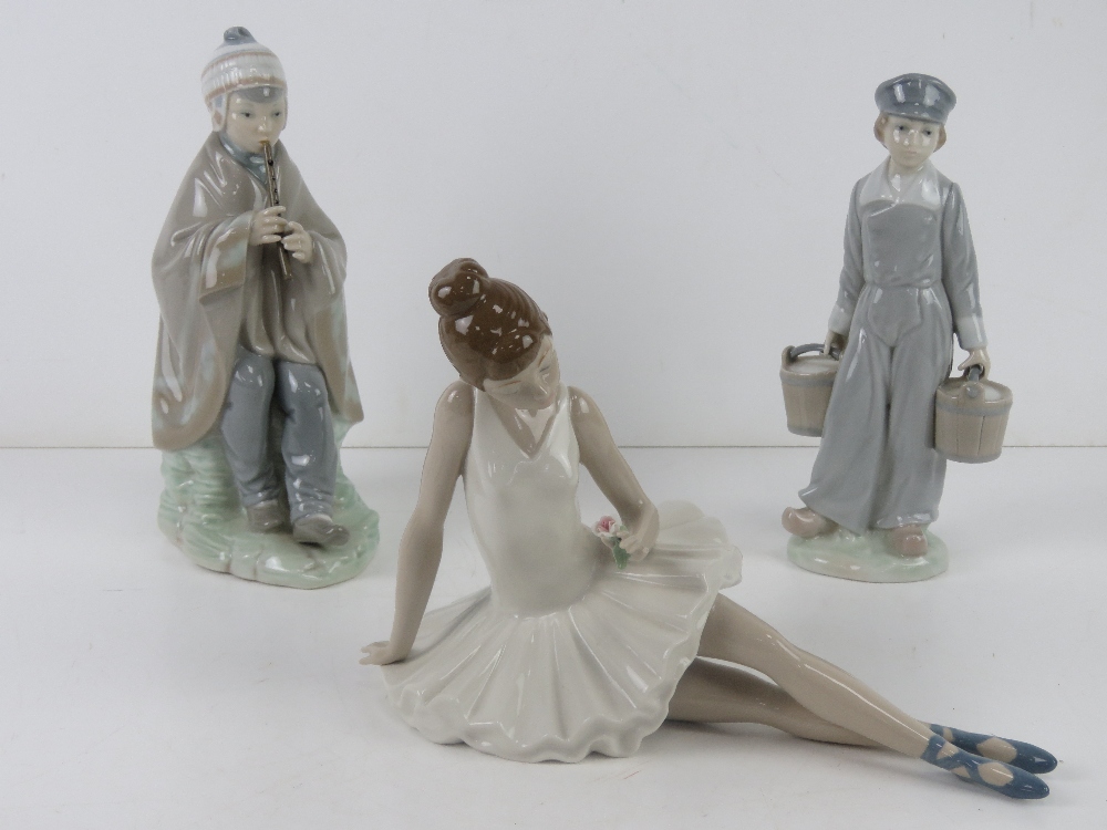 A Lladro figurine of a boy carrying twin