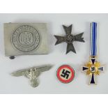 A quantity of reproduction German badges and belt buckle.
