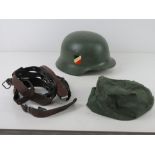 A pair of German 'Y' straps together with a reproduction German Army helmet and helmet cover.