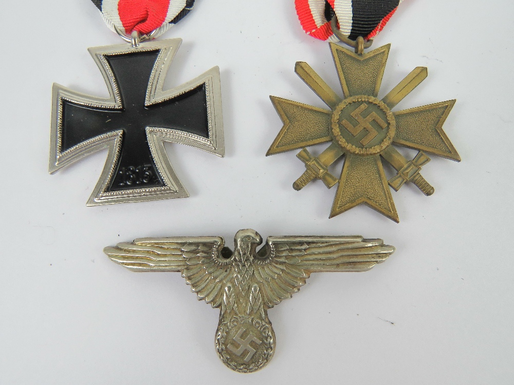 Two reproduction WWII German medals, together with a reproduction badge. Three items.