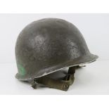 A US Vietnam era helmet with liner.