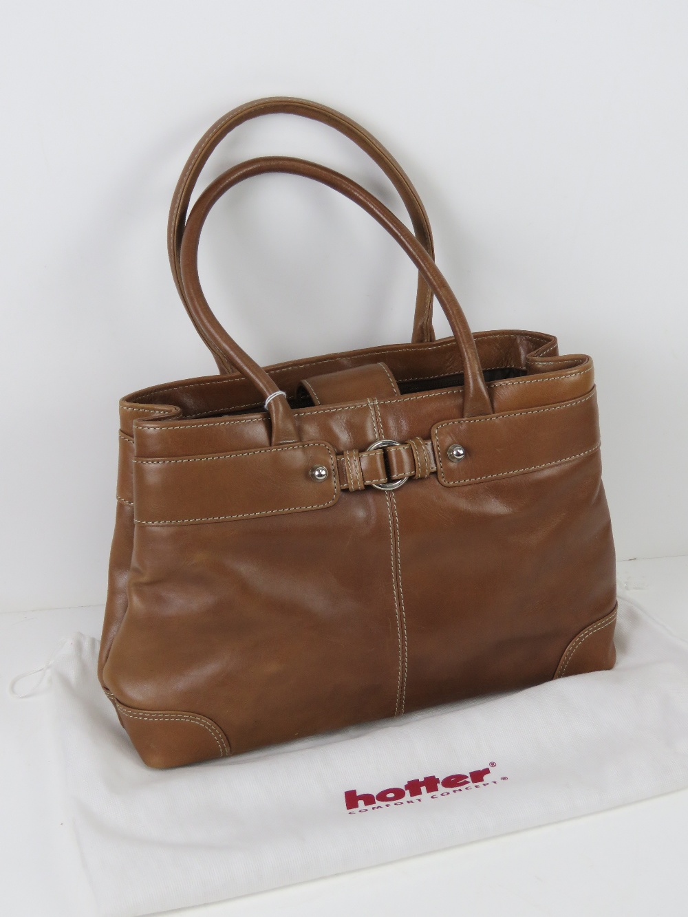 A tan leather handbag having dust cover