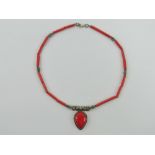 A silver and faux coral necklace having