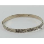 A HM silver hinged bangle having floral