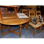 AN OAK GATE LEG DINING TABLE AND FOUR RUSH SEAT DINING CHAIRS.