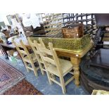 A LARGE PINE KITCHEN TABLE TOGETHER WITH A SET OF SIX RUSH SEAT LADDER BACK CHAIRS.