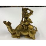 A GILT BRONZE EASTERN FIGURE SEATED ON RECUMBENT CAMEL.