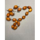 A VINTAGE AMBER OVAL BEADED NECKLACE, THREADED ON METAL WOVEN WIRE.