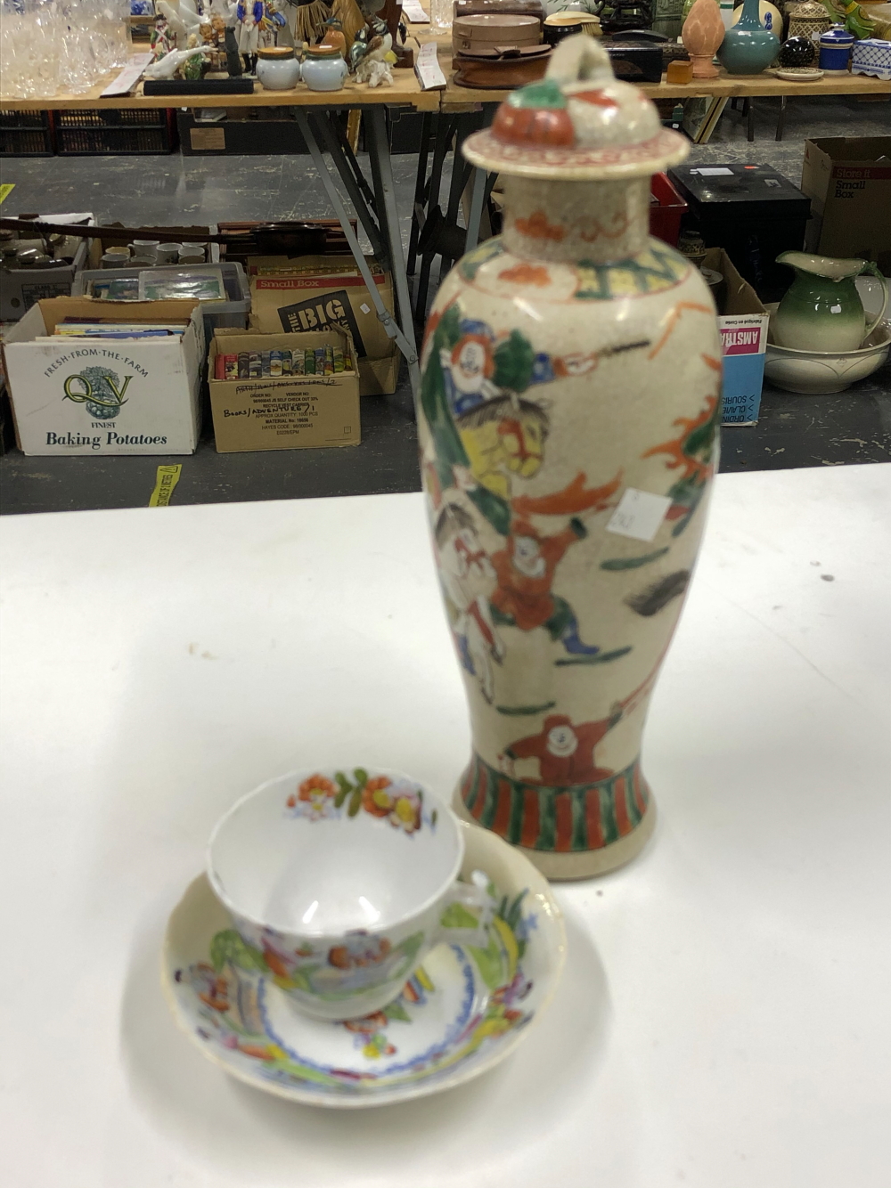 A CHINESE VASE DECORATED WITH WARRIORS, TOGETHER WITH AN ENGLISH TEA CUP AND SAUCER DECORATED IN THE