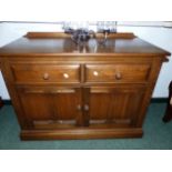 AN ERCOL MID. ELM TWO DOOR SIDE CABINET WITH TWO DRAWERS 95 X 76 CM HIGH