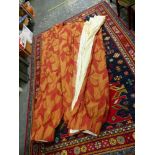 A LARGE PAIR OF CURTAIN DRAPES, BURNT ORANGE AND RED WITH A FLORAL LEAF AND YELLOW STITCHING.