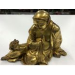 A EASTERN GILT BRONZE FIGURE OF A DEITY SEATED CONVERSING WITH A TOAD TOGETHER WITH A GILT BRASS