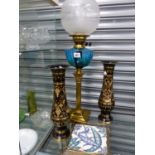 A VINTAGE OIL LAMP, TWO EASTERN ETCHED BRASS VASES, AND A VICTORIAN TEA POT STAND.