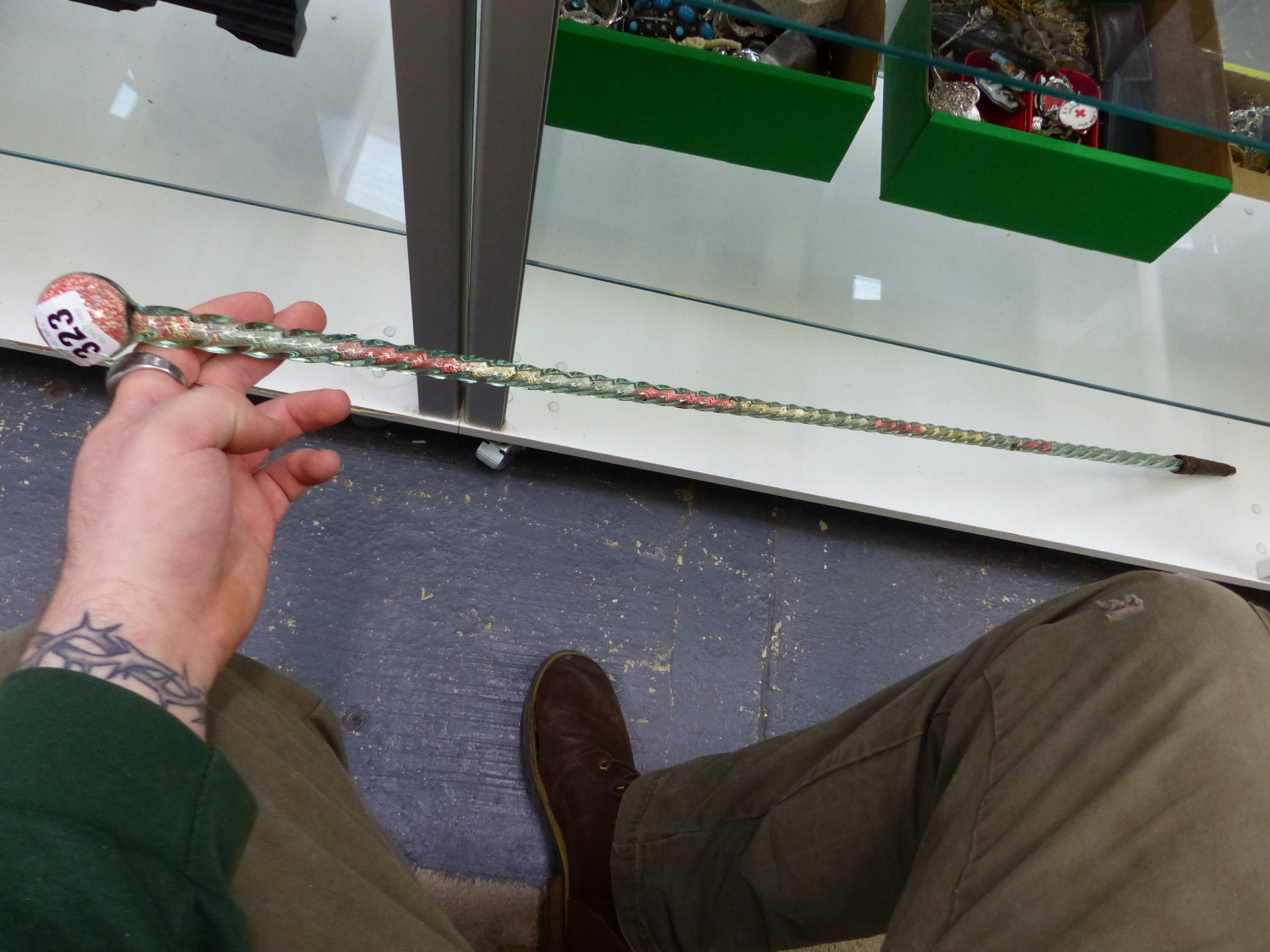 A SPIRAL TWIST GLASS WALKING CANE FILLED WITH COLOURED HUNDREDS AND THOUSANDS. H 116cms.