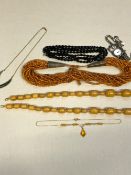 A GRADUATED ROW OF OVAL AMBER BEADS, TOGETHER WITH A GREEN HARD STONE NECKLET, BLACK FACETED