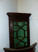 A CARVED OAK SMALL GLAZED CORNER CABINET 81 CM HIGH X 54 CM WIDE