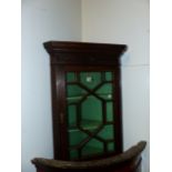 A CARVED OAK SMALL GLAZED CORNER CABINET 81 CM HIGH X 54 CM WIDE