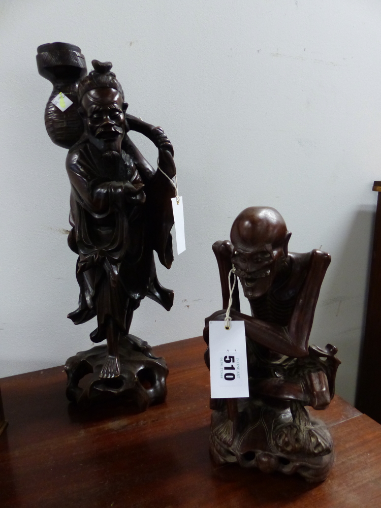 TWO CHINESE CARVED HARDWOOD FIGURES, ONE OF A SKINNY MAN SEATED. H 28cms. THE OTHER OF A