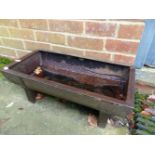 A SMALL CAST IRON FEED TROUGH