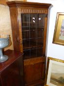 A BESPOKE MADE OAK GLAZED CORNER CABINET.