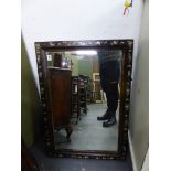 AN ANTIQUE EBONISED AND MOTHER OF PEARL INLAID WALL MIRROR.